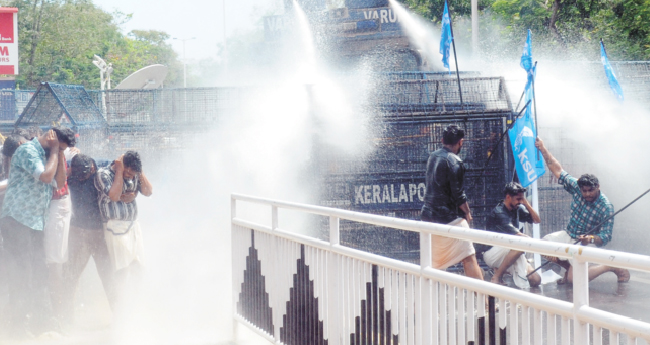 നേ​താ​ക്ക​ളെ മു​ഖംമൂ​ടി ധ​രി​പ്പി​ച്ച് വി​ല​ങ്ങ​ണി​യി​ച്ച സം​ഭ​വം; കെ​എ​സ്‌​യു  മാ​ർ​ച്ചി​ൽ സം​ഘ​ർ​ഷം