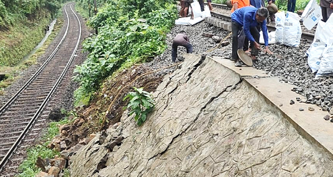 സം​ര​ക്ഷ​ണ​ഭി​ത്തി  ഇ​ടി​ഞ്ഞു​വീ​ണു;  ട്രെ​യി​ൻ​ ഗ​താ​ഗ​തം  ത​ട​സ​പ്പെ​ട്ടു