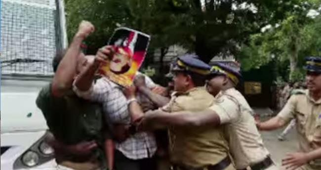 രാ​ജ്ഭ​വ​നി​ൽ ഗോ​ൾ​വാ​ൾ​ക്ക​റു​ടെ ചി​ത്രം; പ്ര​തി​ഷേ​ധ​വു​മാ​യി എ​സ്എ​ഫ്ഐ; ക​സ്റ്റ​ഡി​യി​ലെ​ടു​ത്ത് നീ​ക്കി