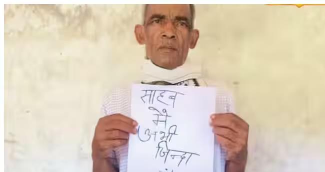 elderly couple with placard for proving they are alive