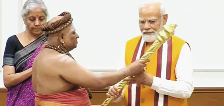പ്ര​ധാ​ന​മ​ന്ത്രി ന​രേ​ന്ദ്ര മോ​ദി​ക്കു പൂ​ജാ​രി ചെ​ങ്കോ​ൽ കൈ​മാ​റു​ന്നു. ധ​ന​മ​ന്ത്രി നി​ർ​മ​ല സീ​താ​രാ​മ​ൻ സ​മീ​പം.